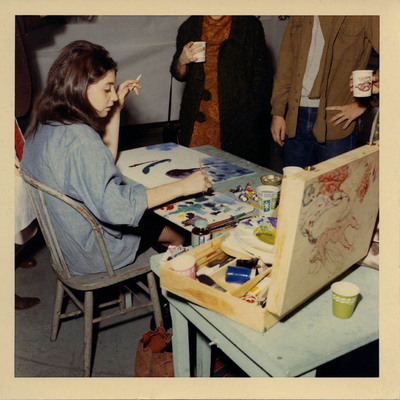 Photograph featuring a student from the Art Institute of Boston demonstrating her art form, painting, during the annual Open House.