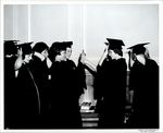 Graduates Adjusting Caps, Commencement ca. 1950s by Paul Allard