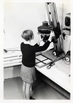 Photo Student Susan Anderson Using an Enlarger in The Darkroom #2 by Art Institute of Boston